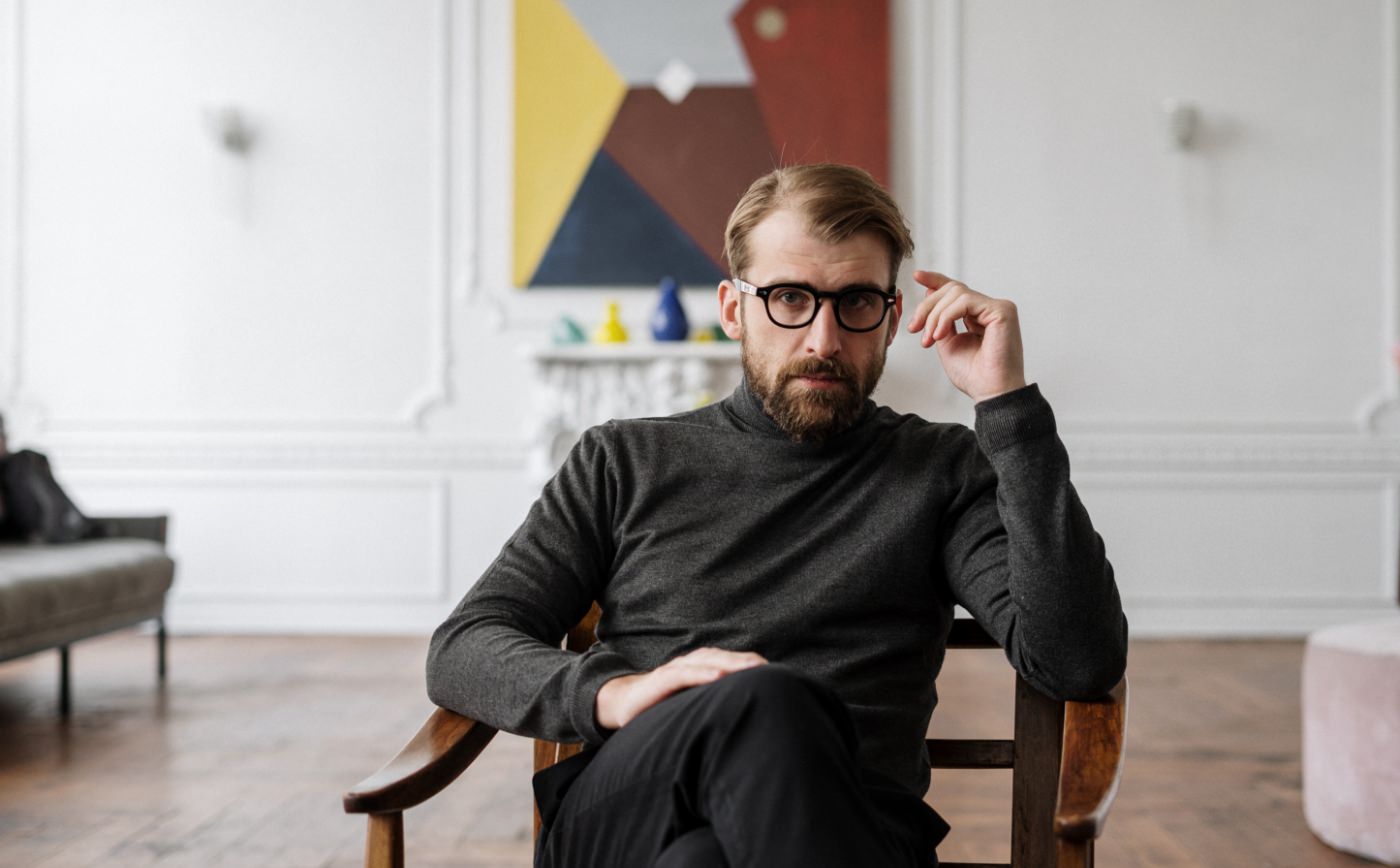 a man wearing specs sitting in a chair