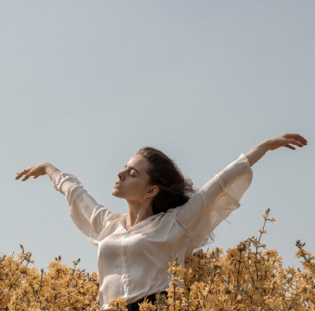 women raising her hand in a field